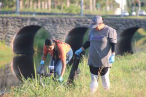 People collecting garbage near river